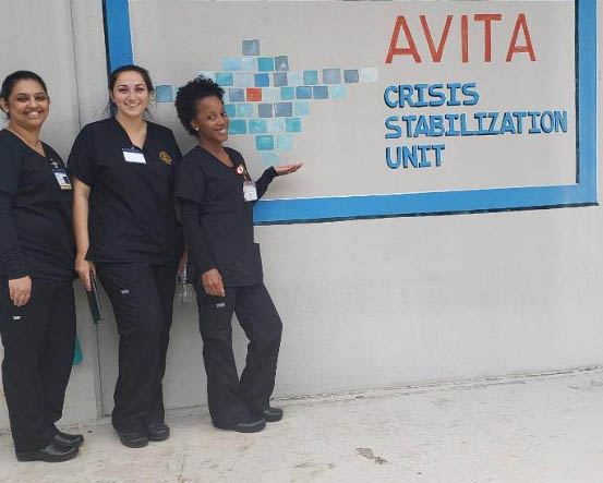 Nurses stand in front of a sign reading "AVITA"