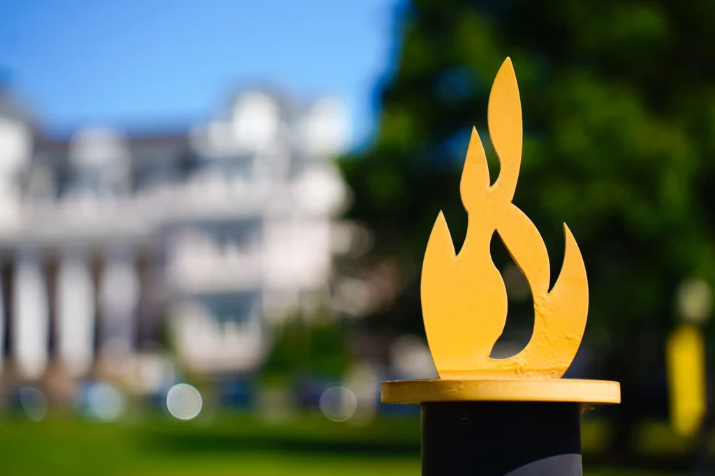 Bright yellow flame element from Brenau logo as part of a metal gate