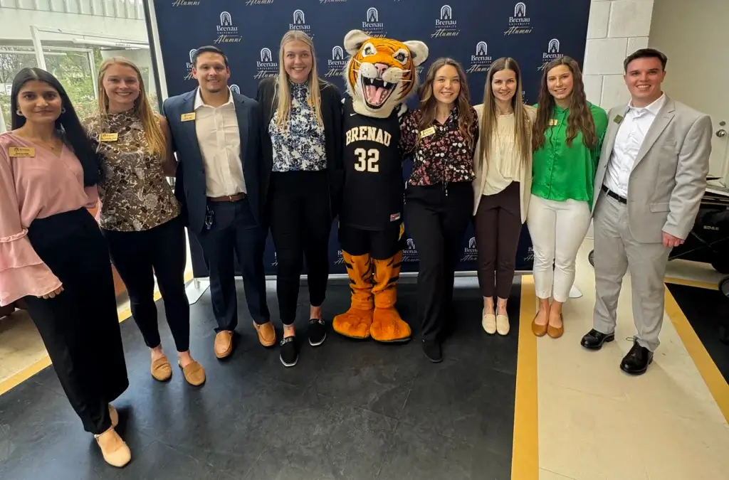PT students post with mascot in front of backdrop